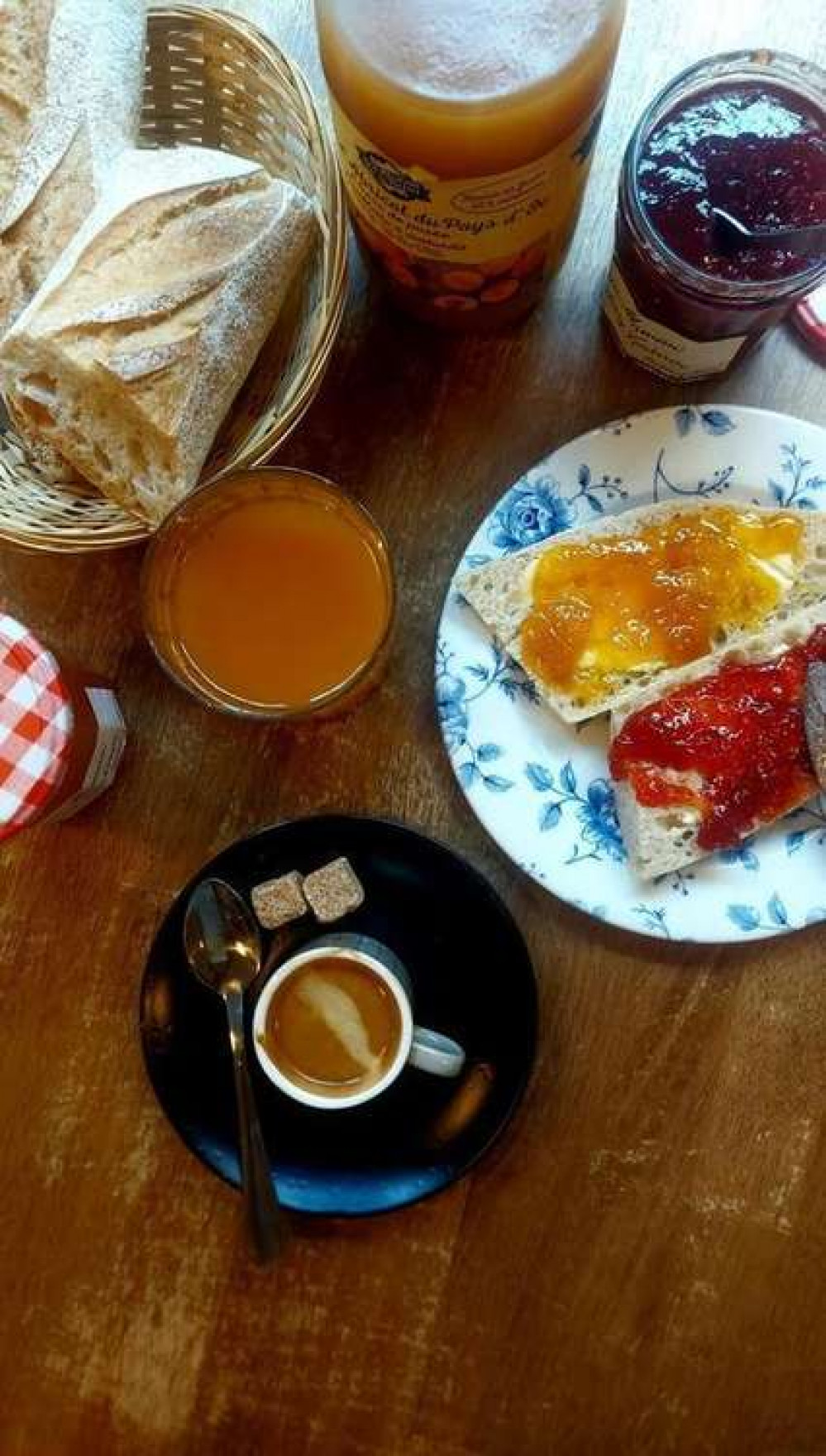 Bread and salted butter with jam, as well as a coffee