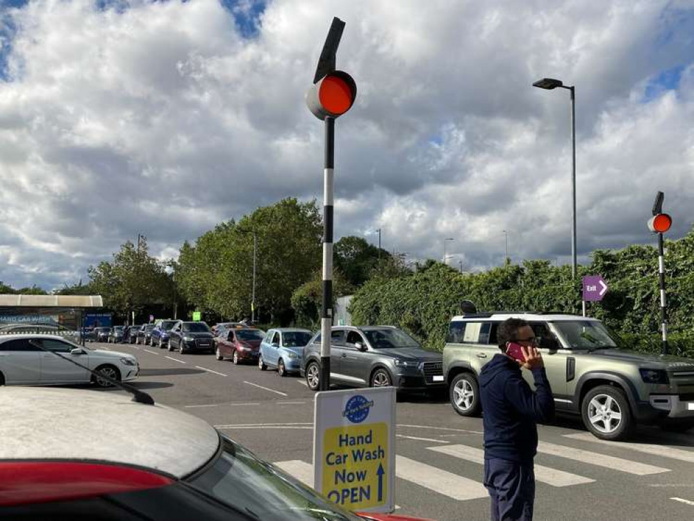 A string of cars wait in the Sainsbury's car park for fuel. Credit: James Mayer.