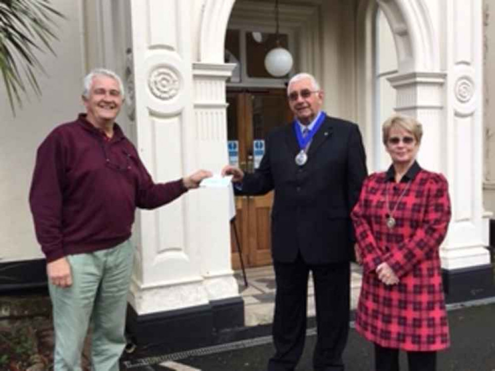 David Force of Starcross Masons presents his cheque to John and Linda Petherick