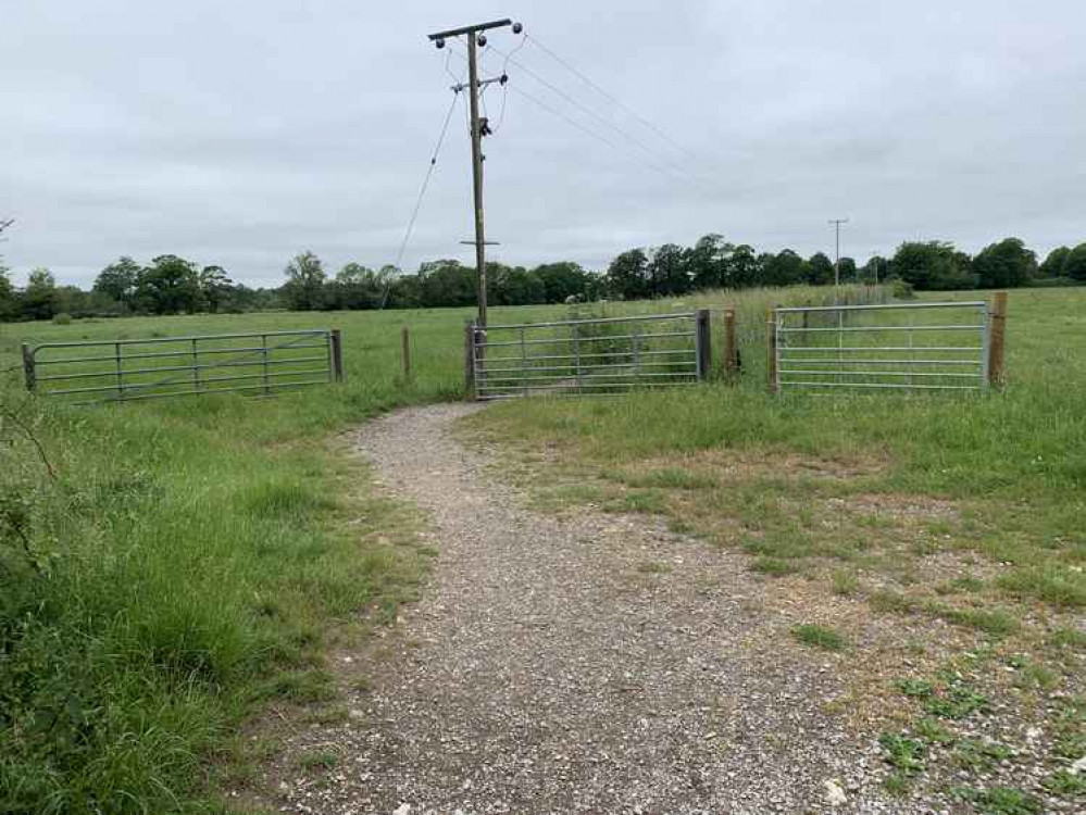 Follow the path round to the left and through the gate to follow along the path