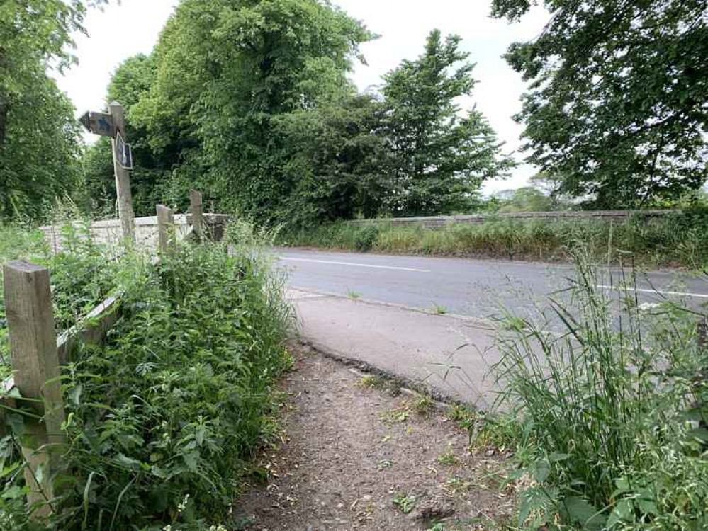 When the path meets the road, turn left and walk along the pavement