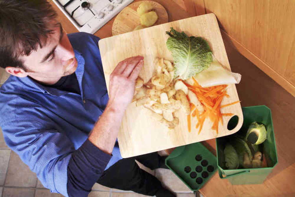 Man Putting Veg Peelings Into A Food Waste Caddy. CREDIT: Somerset Waste Partnership.