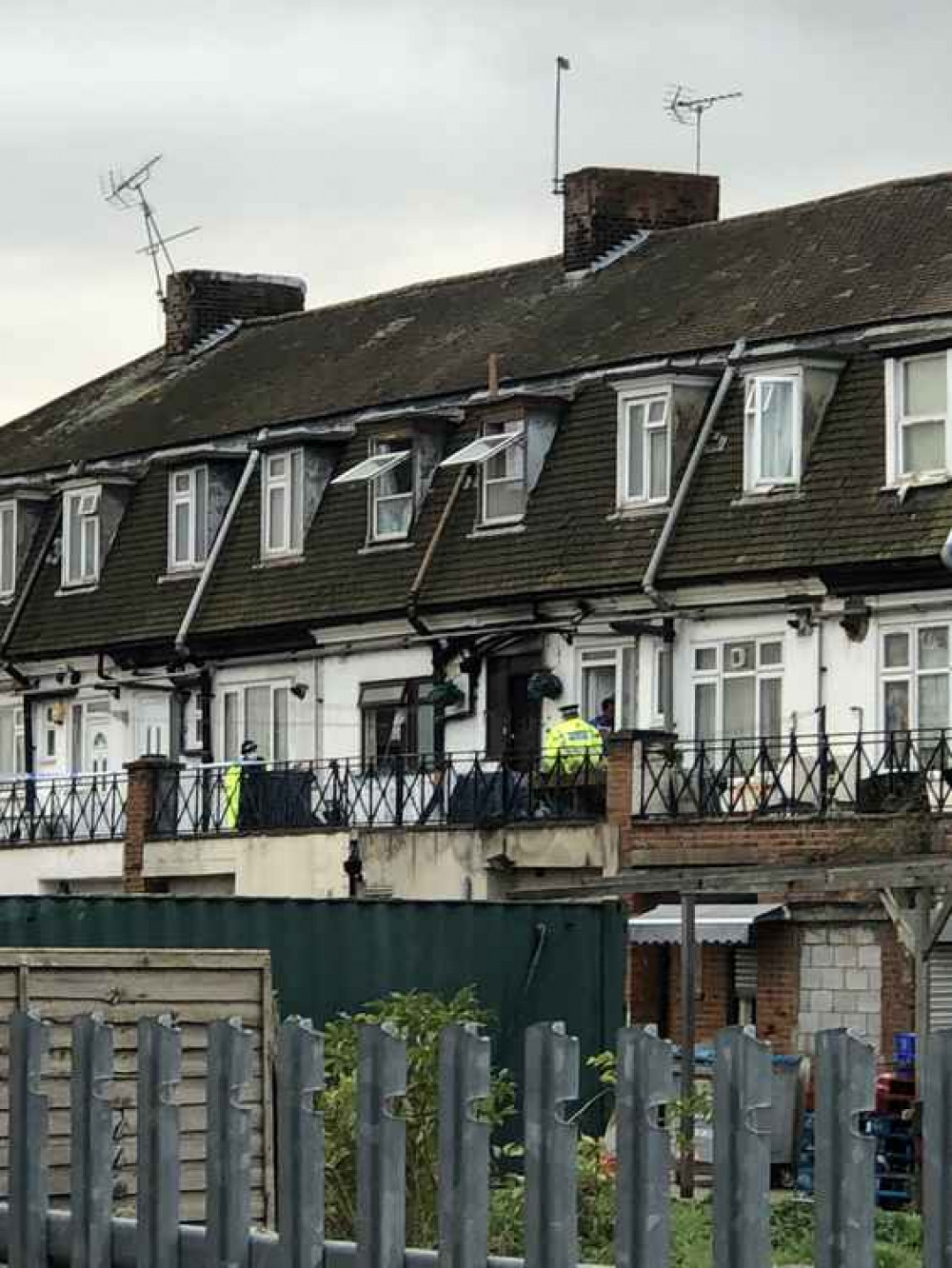 People stand guard at the affected homes this morning as an investigation got underway.