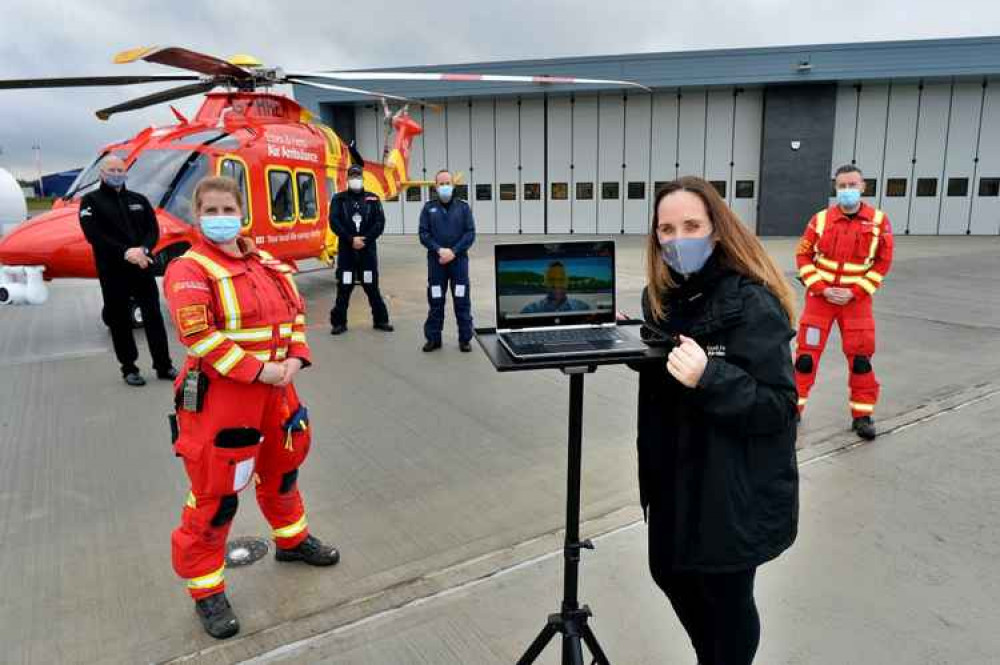 Mark Hart hands over the new base virtually to Jane Gurney accompanied by (L-R) Cliff Gale, Gaynor Wareham (Critical Care Paramedic), Lee Burling (Pilot), Clive Sturdy (Co Pilot) and Ben Clarke (Pre-hospital Care Doctor).