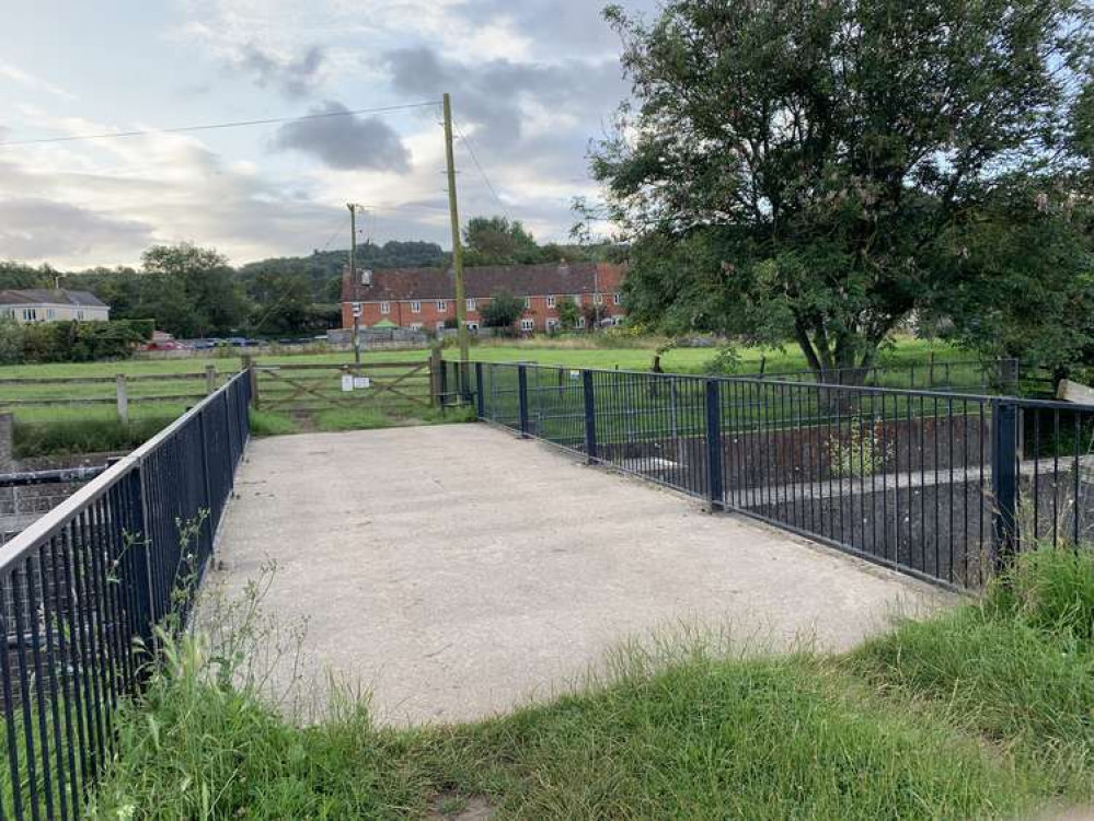 Cross the bridge and over the metal stile