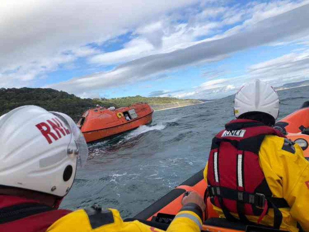 Lyme Regis lifeboat crew approach the old lifeboat Gryphon off Seaton beach (photo by Andy Butterfield)