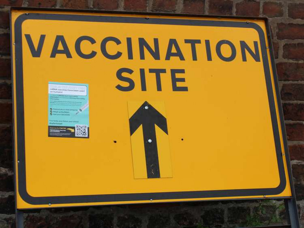 Congleton: A vaccination sign on Market Square, with anti-vaccine print material on the left of the sign.