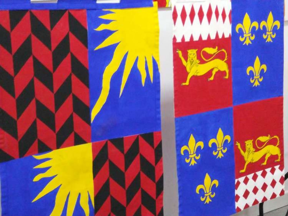 Two of the heraldic flags finished at the last workshop, and more will be completed this Saturday to be placed around town next year. (Image - Patti Pinto Facebook)