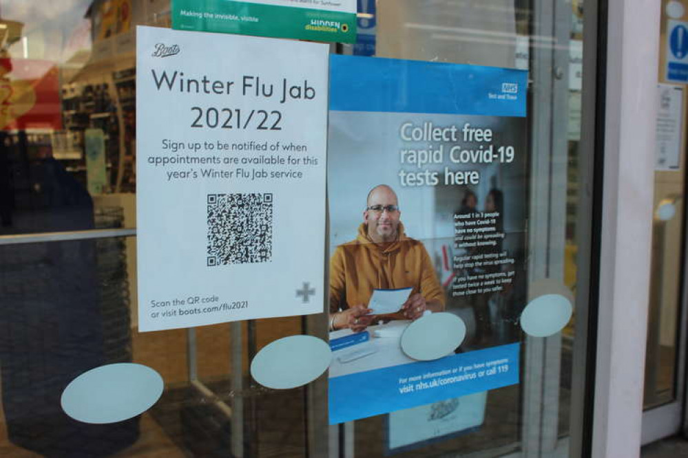 Coronavirus in Congleton: Bridge Street Boots with COVID and flu posters in their window.