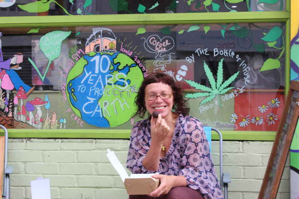 Greta sits in front of the stunning art for the café, which was done by local artist Ella Maisie Brame in April. Her Instagram is @_emb.art_.