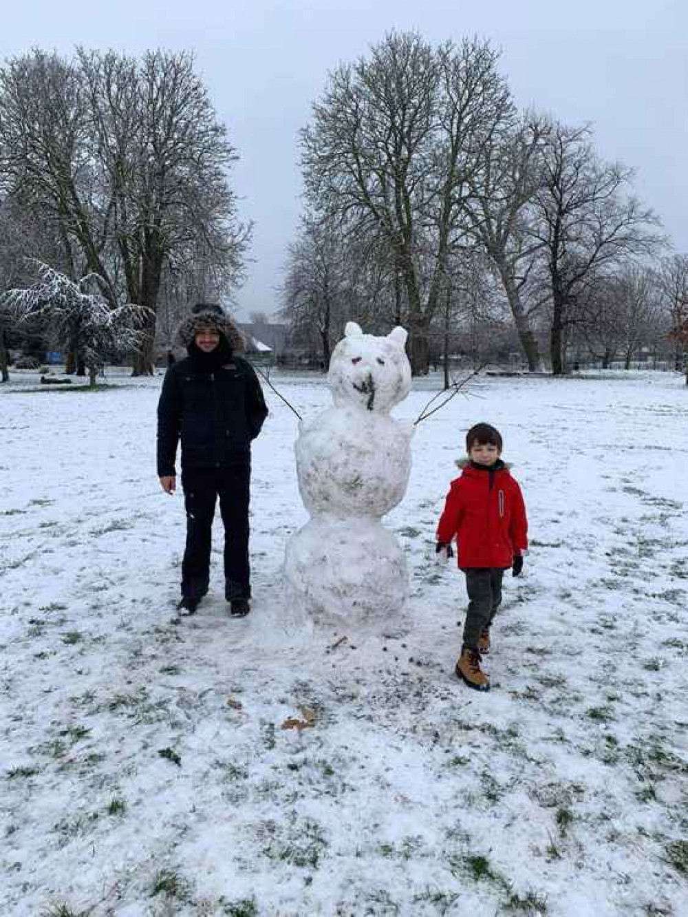 Father and son, Philipos and Harry with their snowman in Acton Park. Image Credit: Gaelle Valcke