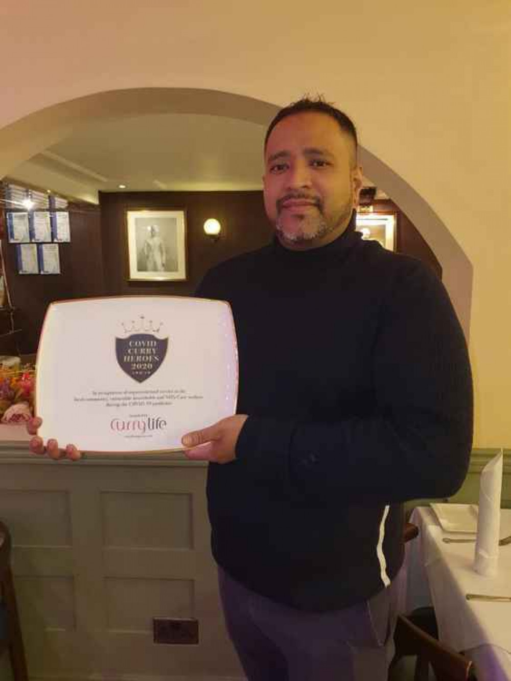 Haweli owner, Manik Miah with the COVID Curry Hero award he received in December