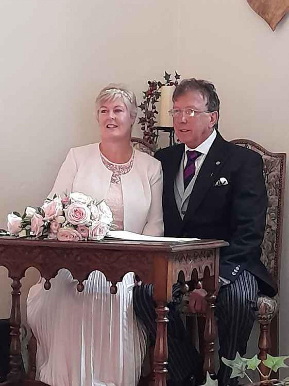 Jackie and Mervyn signing the register at their marriage service in St Margaret's Hall, Honiton