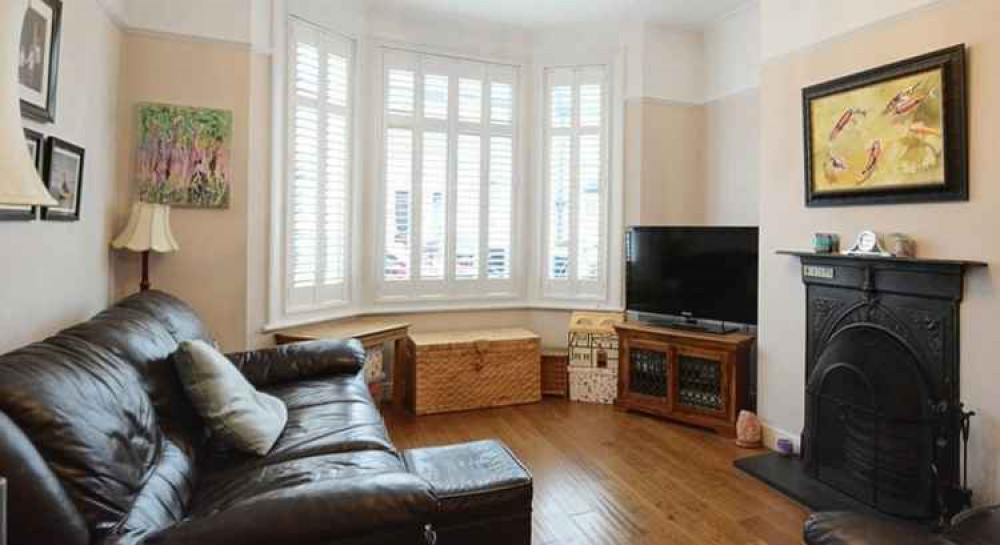 The lounge features a bay window and a cast iron fireplace