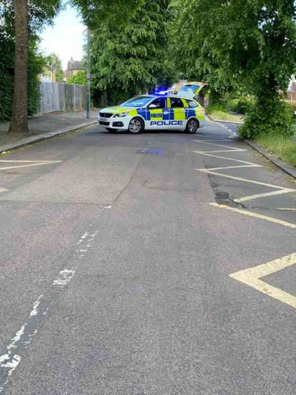 A police car seals off the scene.