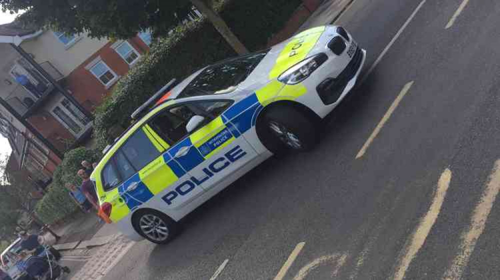 A police car blocks the road