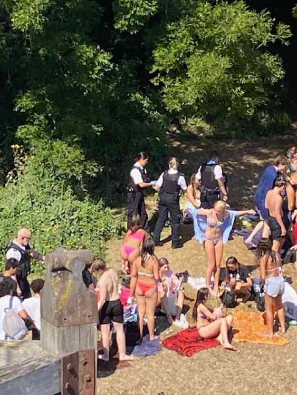 Uniformed police move into the Teddington Lock beach area to disperse crowds