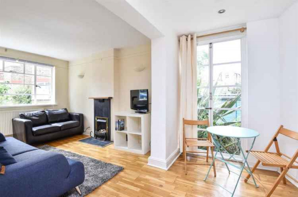 A second view of the living room from the dining area with its french doors leading to the garden