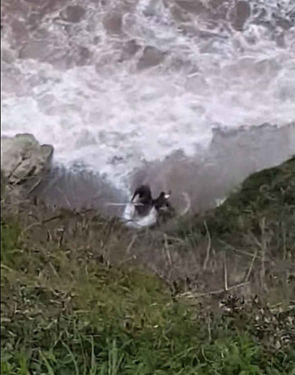 Another still shows the men washed up on the rocks in rough sea conditions.