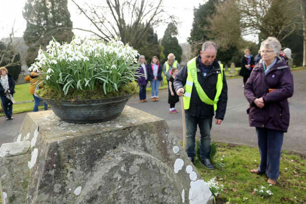 Planting snowdrops on the grave of Snowdrop King James Allen, as part of the Celebratory Procession during the 2019 festival