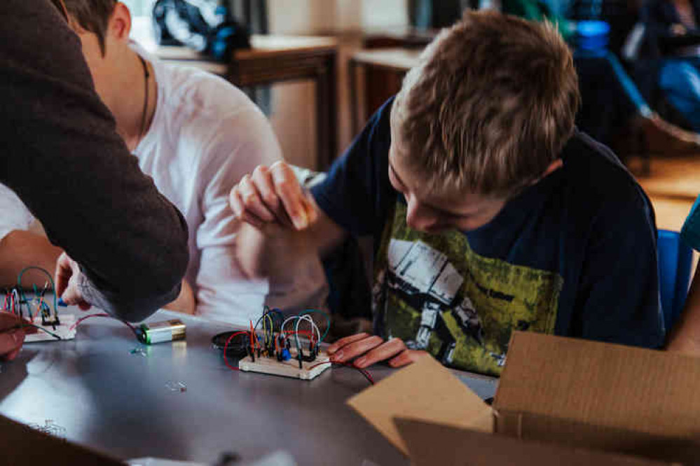 Teenager at workshop performs music on an electronic synthesiser he had just made at a Moogie Wonderland workshop