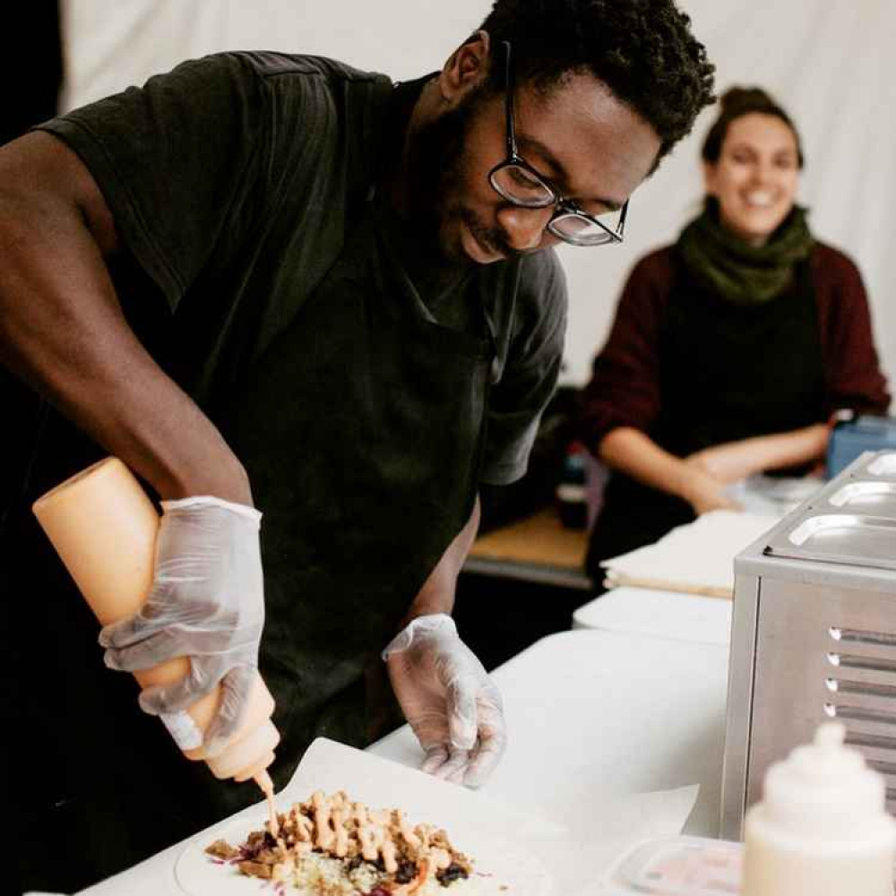 Andre and Angie serving food at Sloth and Sparrow.