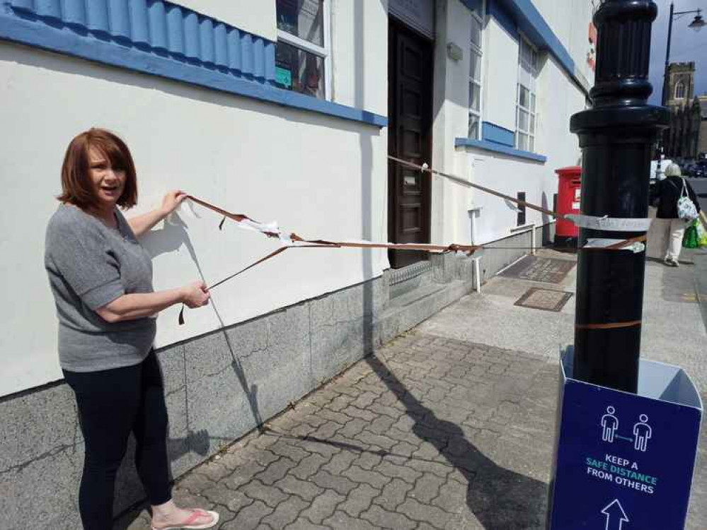 Deco owner Debra Lock affixing her barrier to the wall