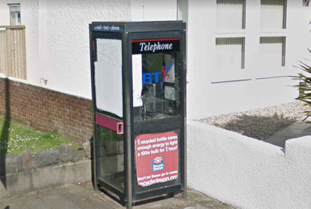 A glass phone box adjacent to All Saints' Church