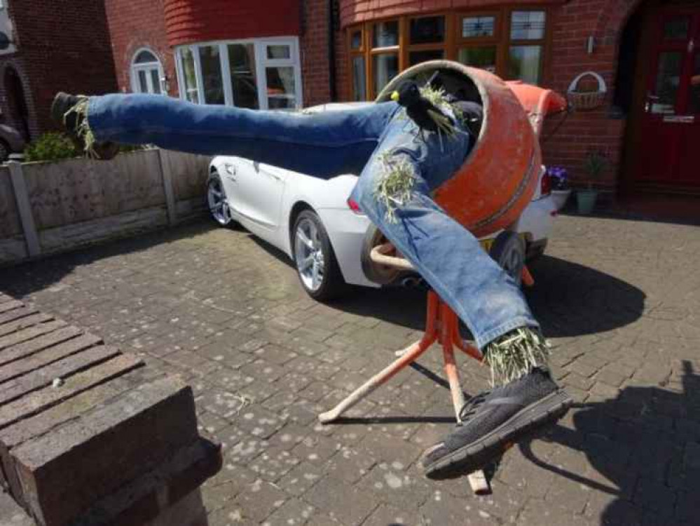 A scarecrow in a cement mixer.