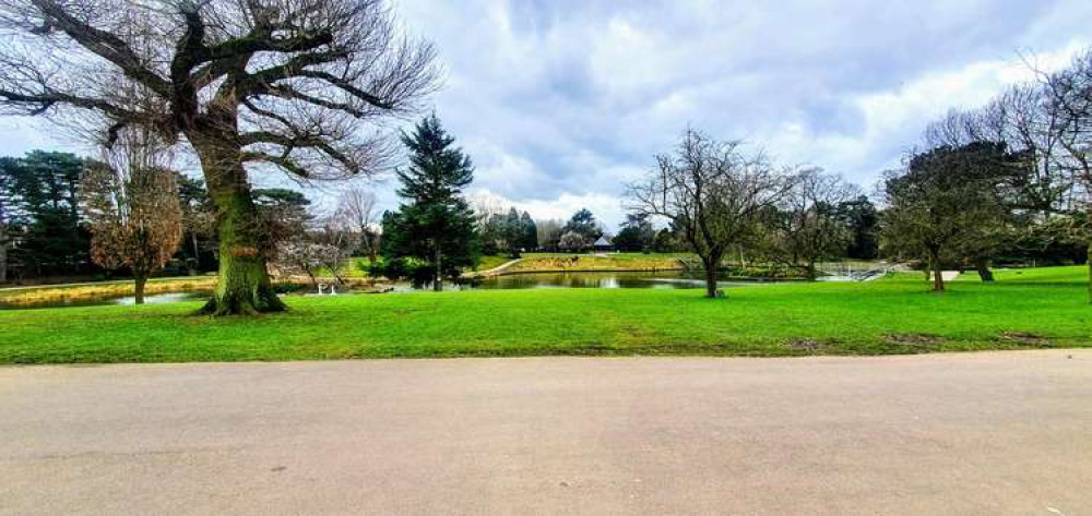 The view of the lake from a set of benches in Queens Park.