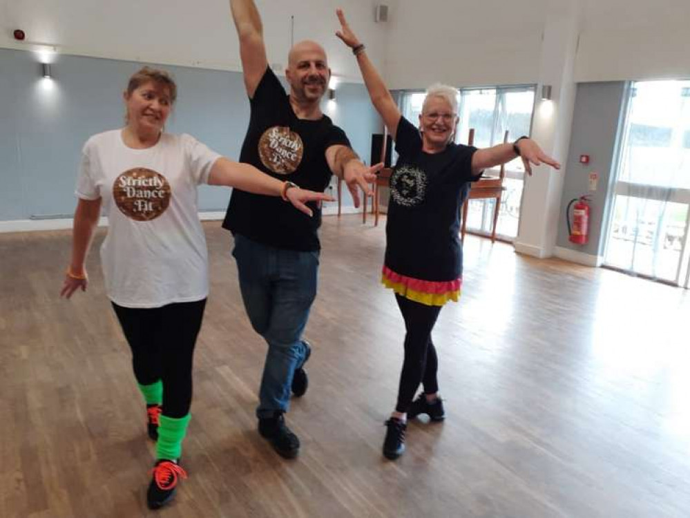 Students Anne Bridgett (left) and Glynis Roberts model the T-shirts with Mark after a class.