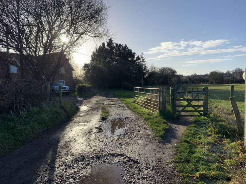 Go through the gate on the right opposite the house