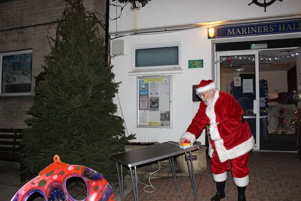 Father Christmas switches on the Christmas lights outside the Mariners Hall in Beer