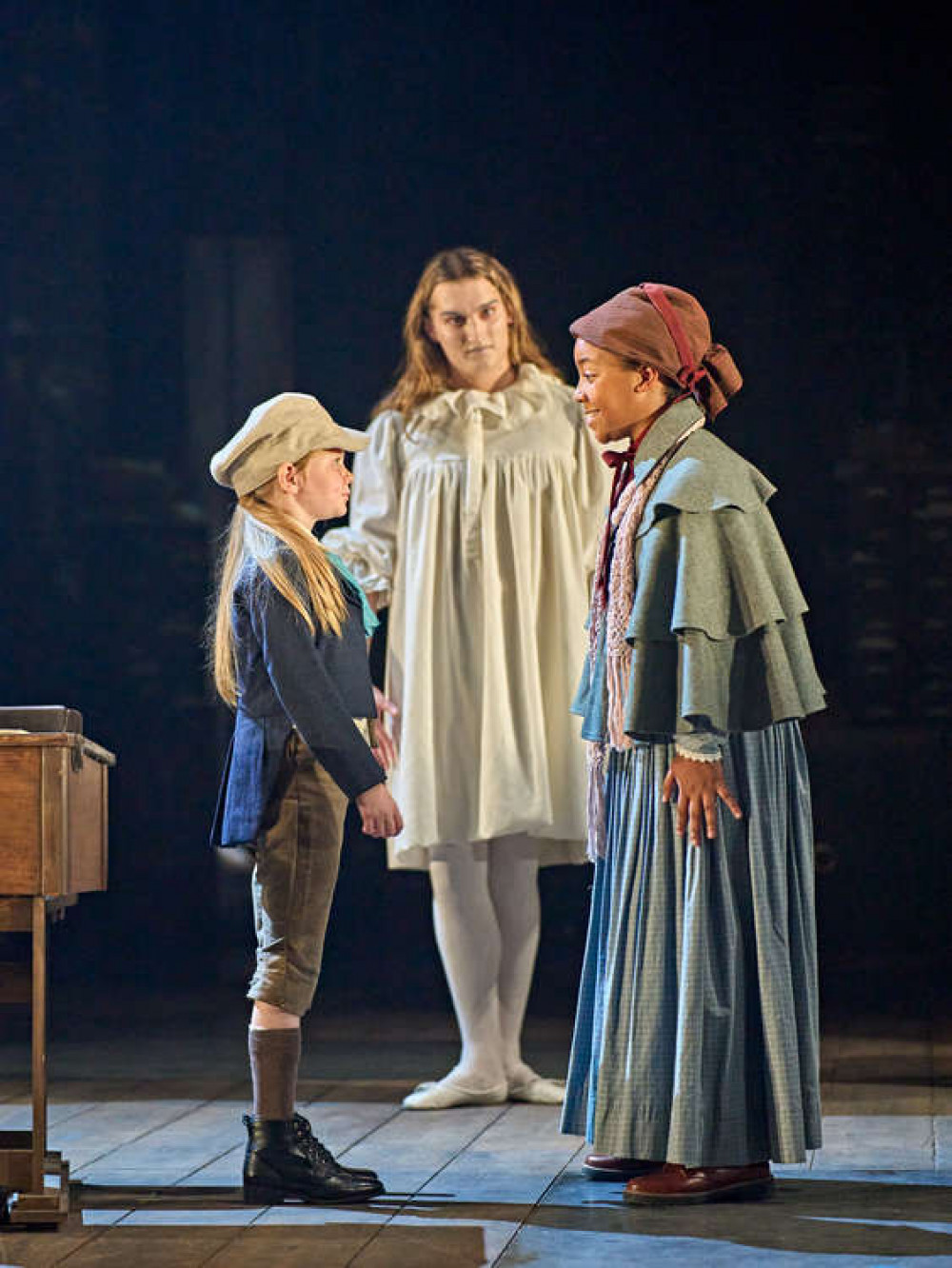 Lauren as Young Scrooge, one of the many characters she portrays in the production. A Christmas Carol © Nottingham Playhouse. Photo by Manuel Harlan. (L-R) Lauren Tanner as Young Scrooge, Jo Eaton-Kent as The Ghost of Christmas Past, Esmé Tchoudi as Fan