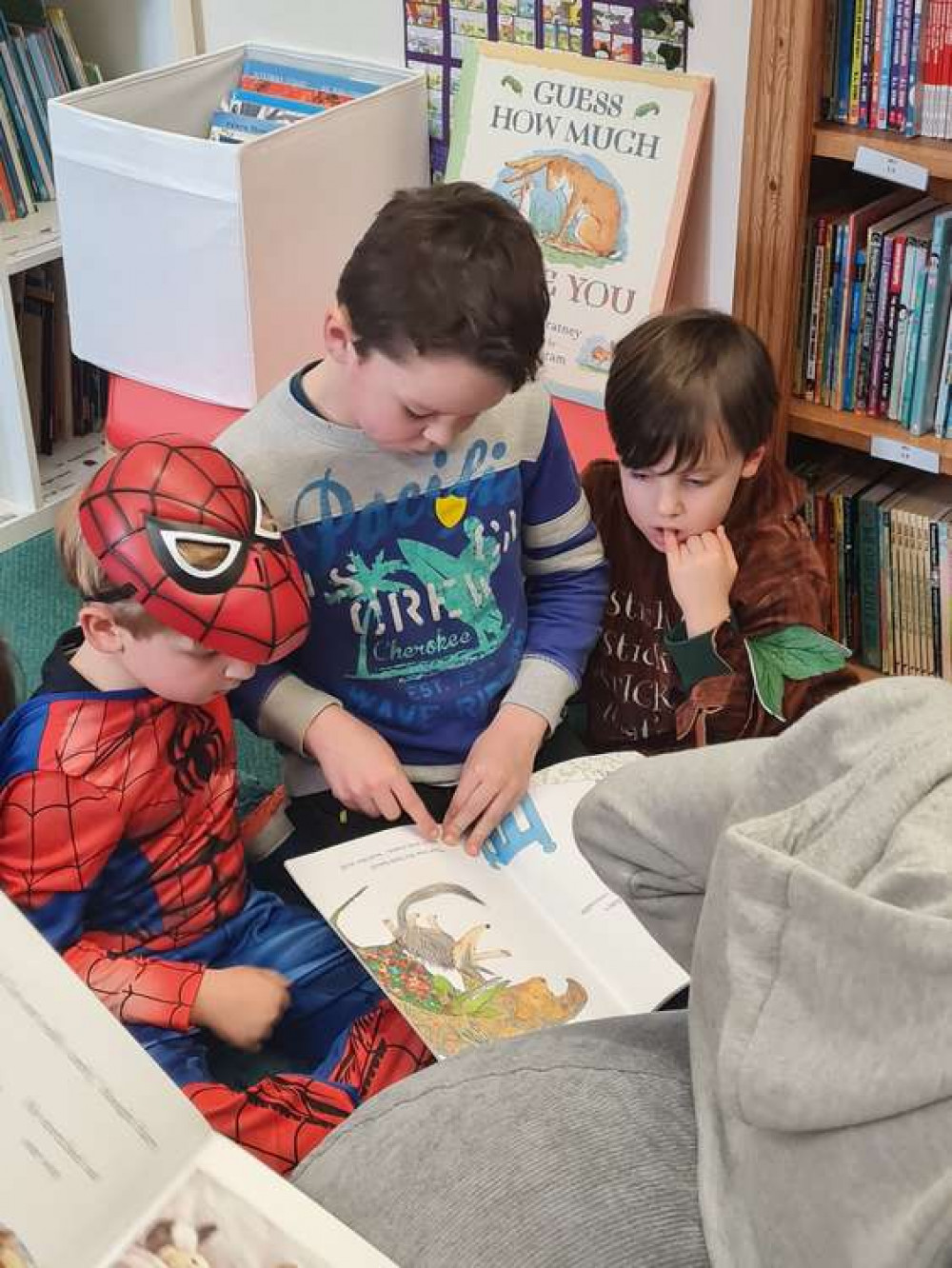 Children, dressed in costume for World Book Day, enjoy books in the new library