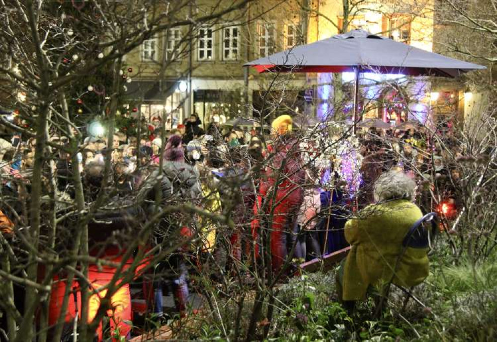 Clapham resident Miriam Margolyes sat amid The Polygon's flowerbeds as children in St Mary's Primary School and Heathbrook Primary School choirs performed festive songs (Image: Issy Millett, Nub News)