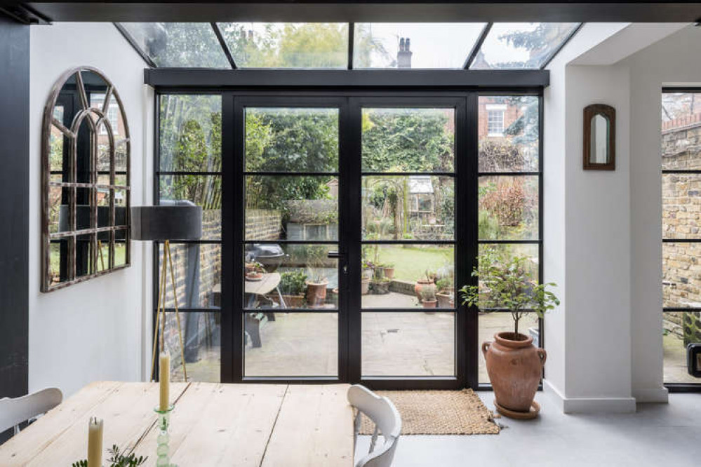 Full-height black-framed doors open out to the garden (Image: The Modern House)