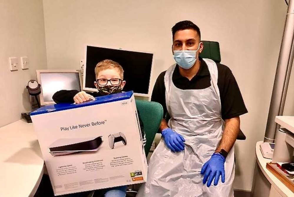 Alife Barney with his Christmas present and Specsavers optician Adnan Nawaz