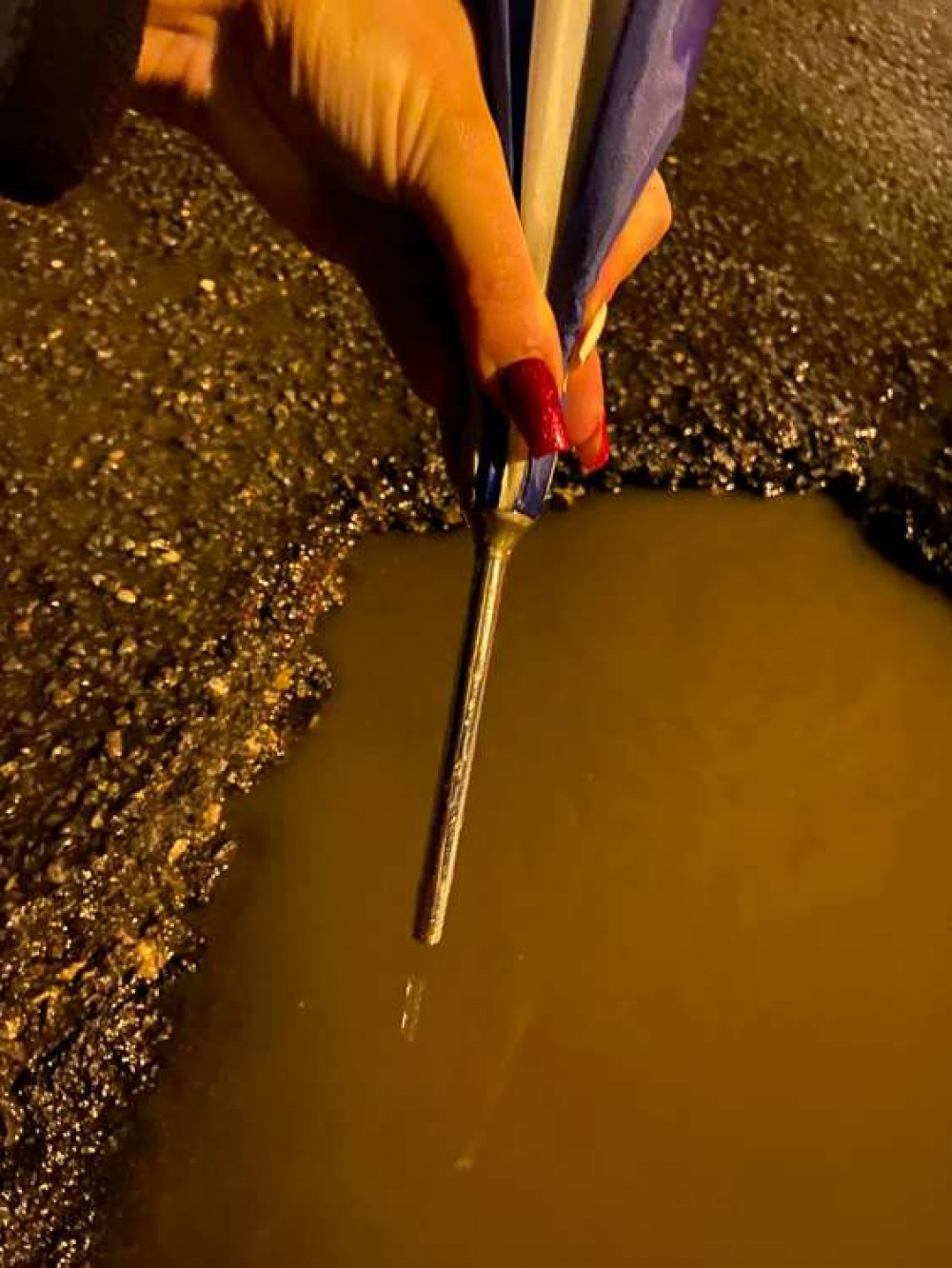 One resident measured the pothole with their umbrella.