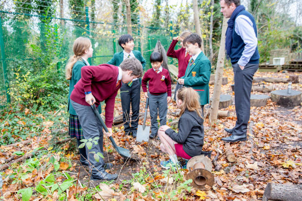 Children from Holy Family Catholic Primary plant a St Benedict's anniversary tree in their forest school. (Image: St Benedict's School)