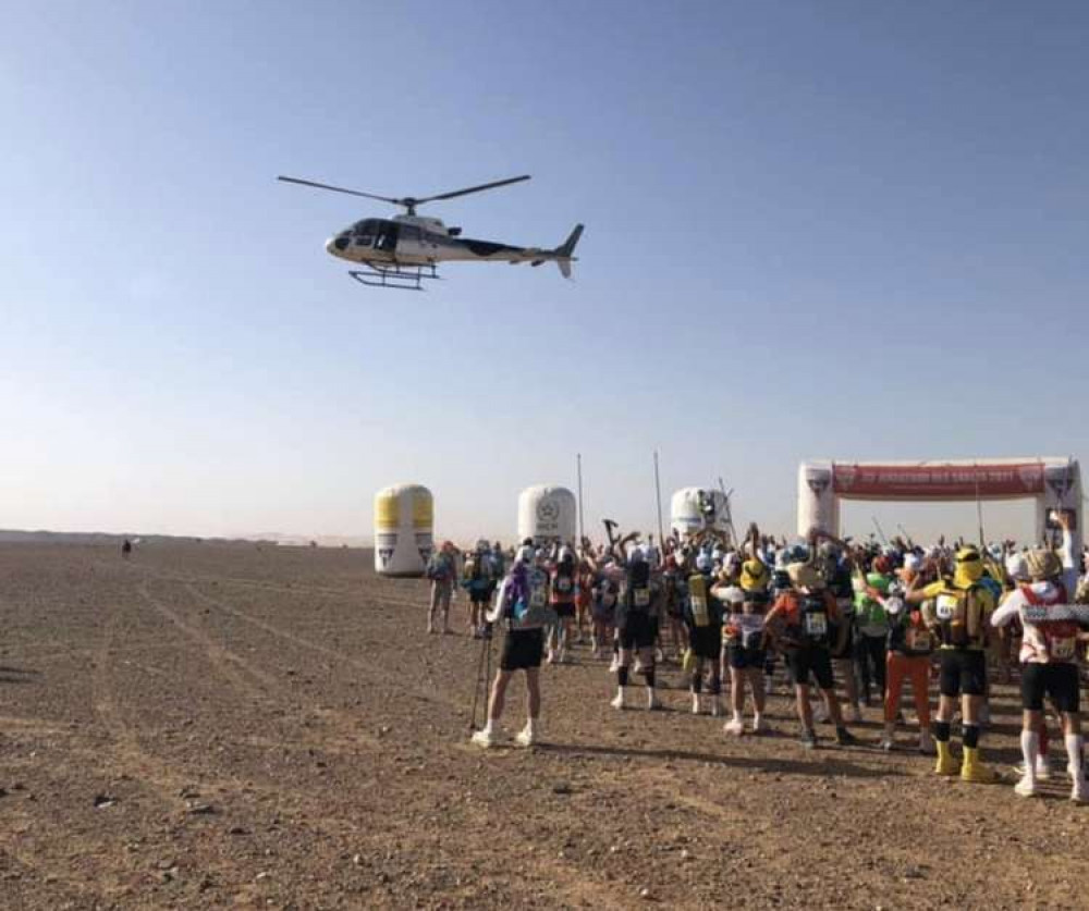 Runners are circled by a helicopter in the Saraha Desert during the race. CREDIT: James Bull