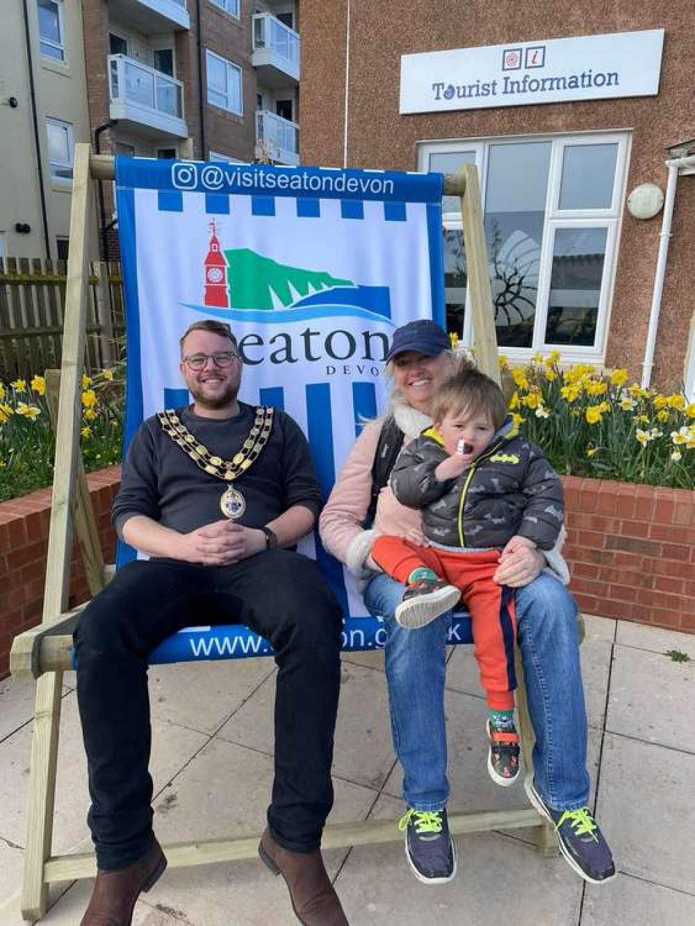 Cllr Ledger tries out the giant deckchair outside the Tourist Information Centre (photo credit: Seaton Town Council)