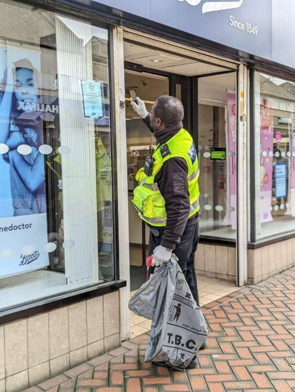 An officer gets to work to remove stickerts from shutters.