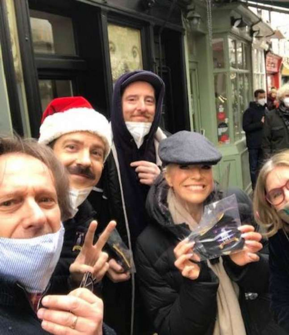 Actors Jason Sudeikis (in Santa hat) who plays Ted Lasso and club owner Rebecca (in peak cap) played by Hannah Waddingham outside his Richmond TV home.