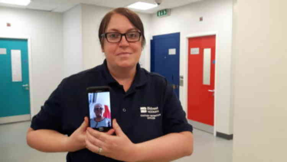 Conference call: Detention officer Clare Harvey with custody visitor Sue Such pictured on the mobile phone