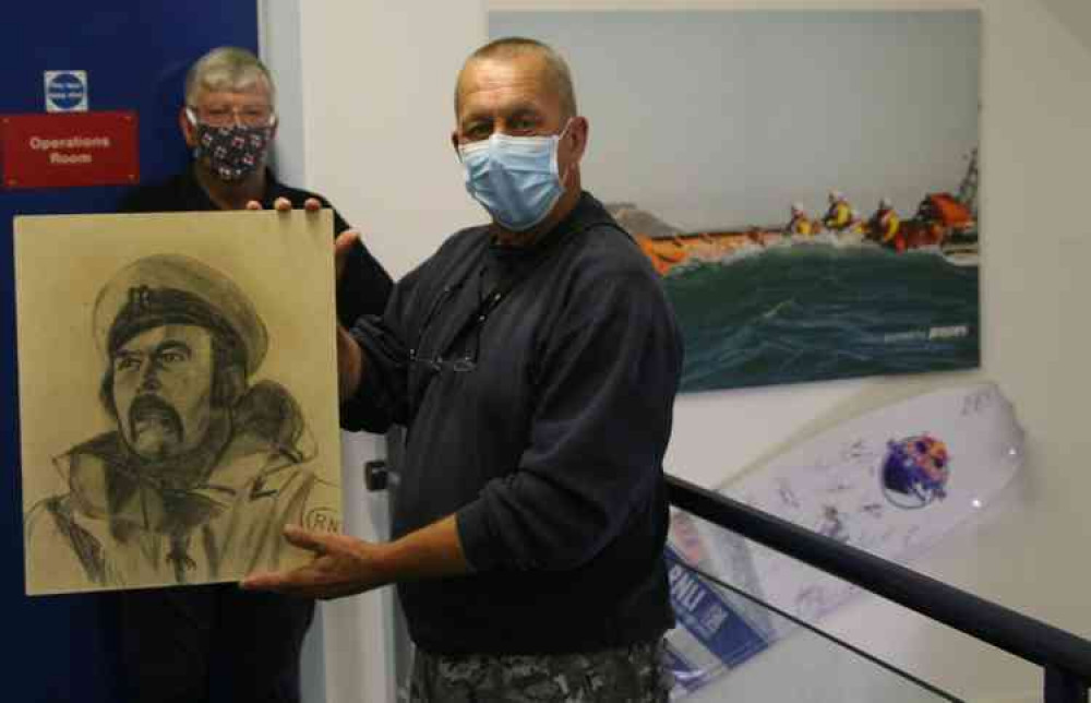 Mark Shephard, grandson of the artist Camille Moore, holding the portrait of John Hodder with lifeboat operations manager Nick Marks in the background. Mark Shephard, grandson of the artist Camille Moore, holding the portrait of John Hodder with lifeboat operations manager Nick Marks in the background.