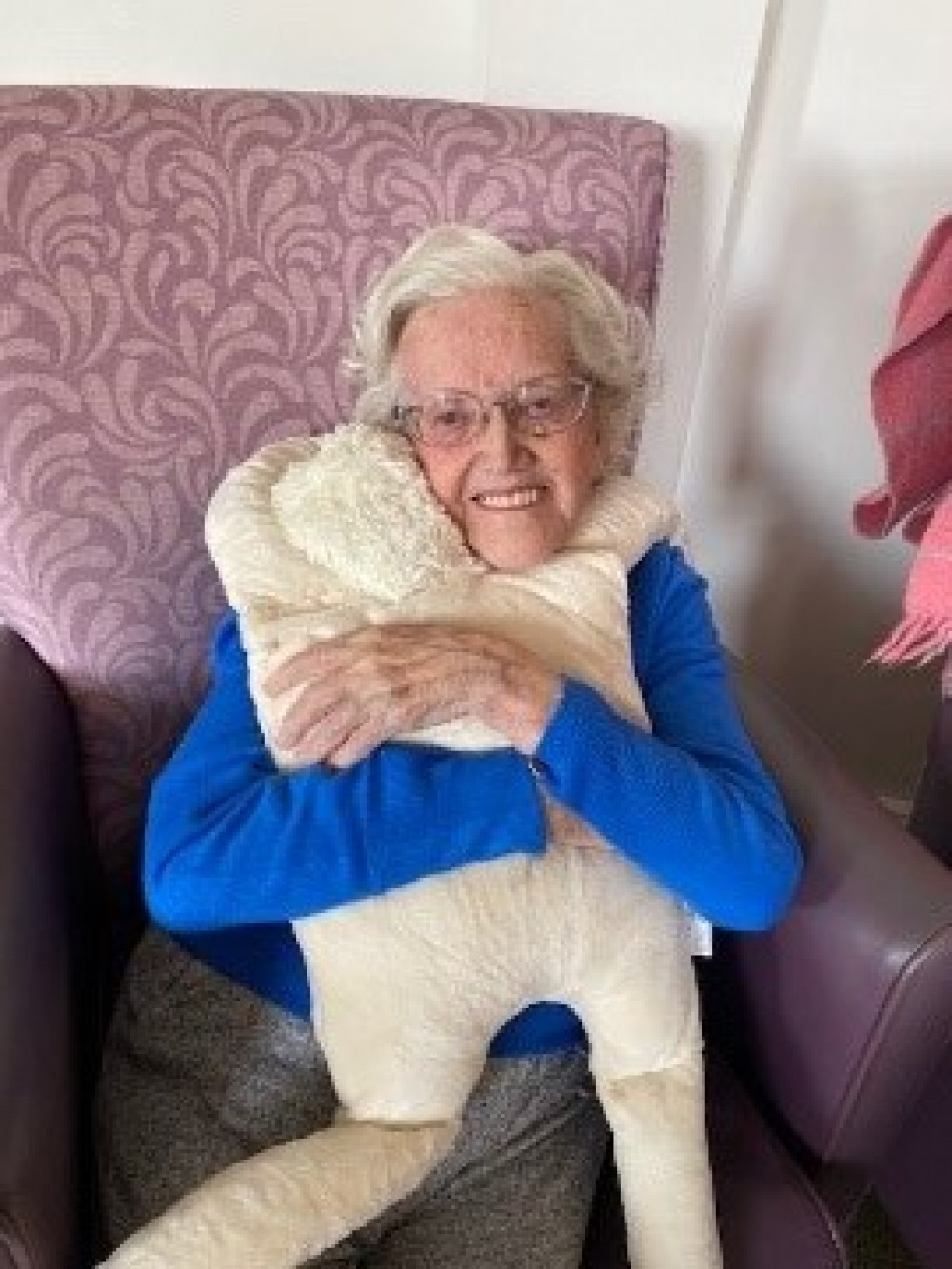 Joan Denning giving a loving hug to one of the dolls. (Image credit: Methodist Homes - MHA)