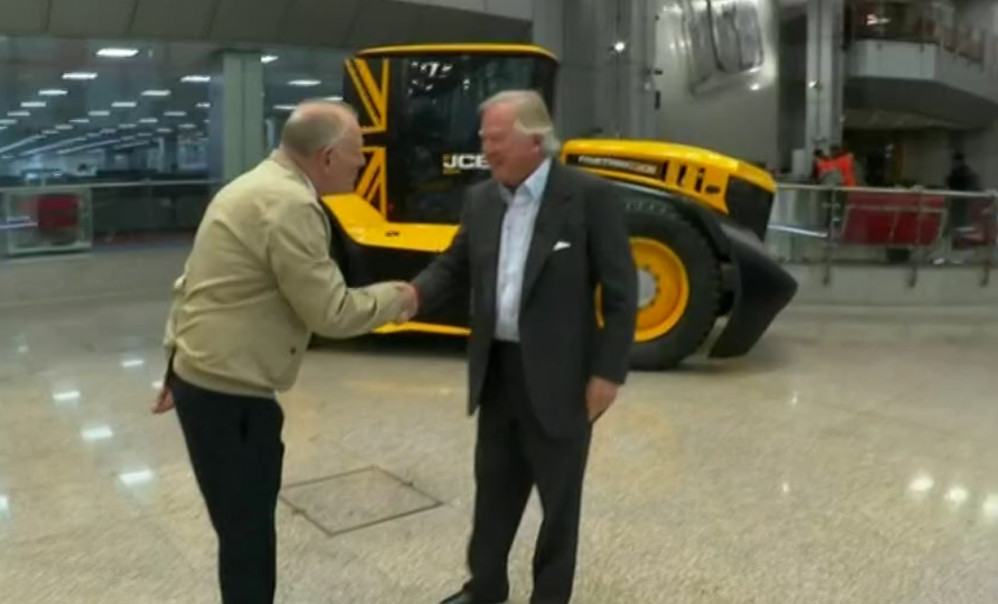 Harry (left) was offered a role by JCB chairman Lord Bamford (right). Image credit: BBC