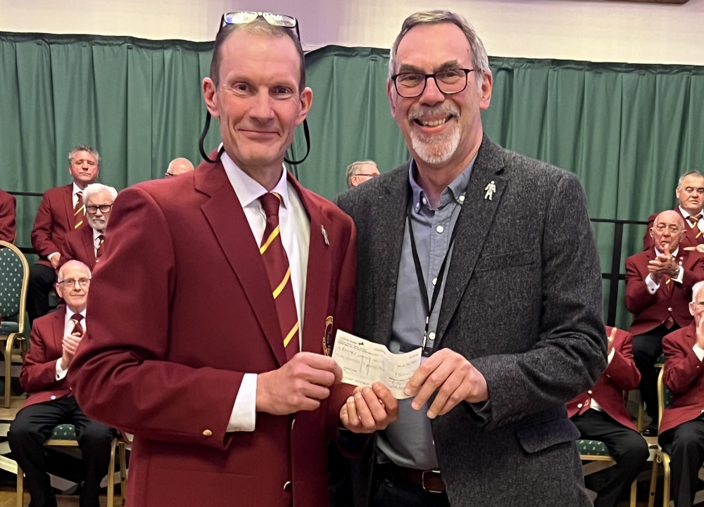 Choir secretary Andy Maxfield presents Phil Tearle with a cheque for £500.