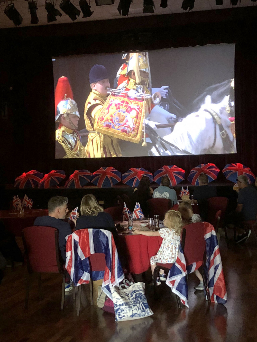 Families watch the Trooping of the Colour at The Gateway Theatre